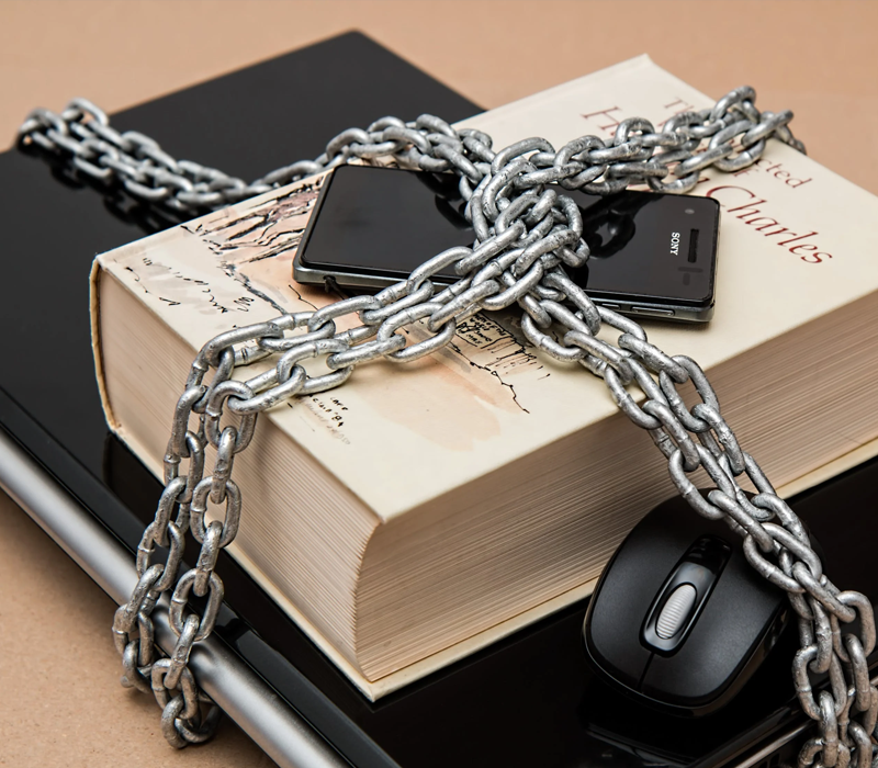 Book and mobile phone tied to a laptop depicting time and motion study